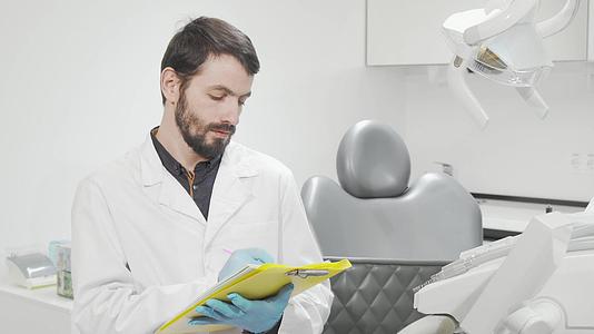 专业牙医在他的办公室填写医疗文件视频的预览图
