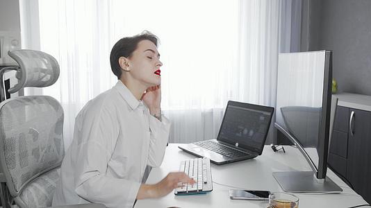 从事计算机工作的年轻富有的年轻女性在工作中强调视频的预览图