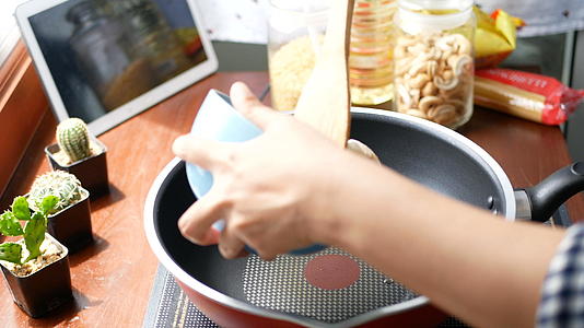 女人把虾放在锅里搅拌准备做饭视频的预览图