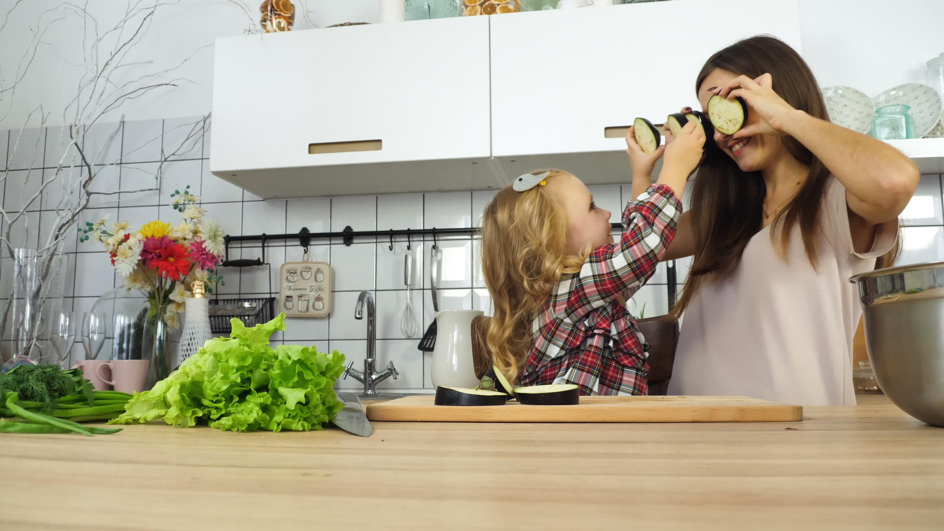母亲和女儿在厨房里玩耍视频的预览图