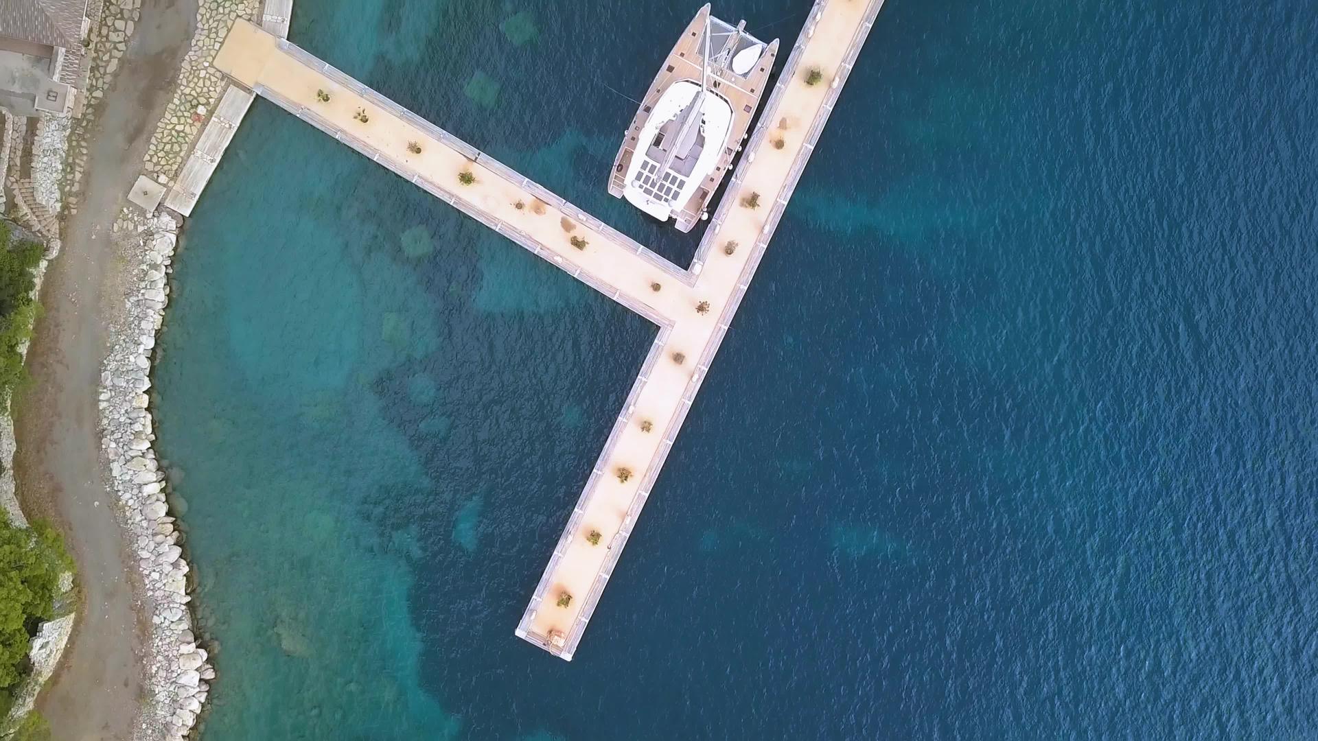 船港有一艘停泊在岸边的白色大卡达马兰游艇视频的预览图