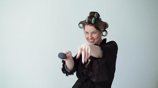 女人卷发穿着浴袍跳舞对着梳子唱歌视频的预览图