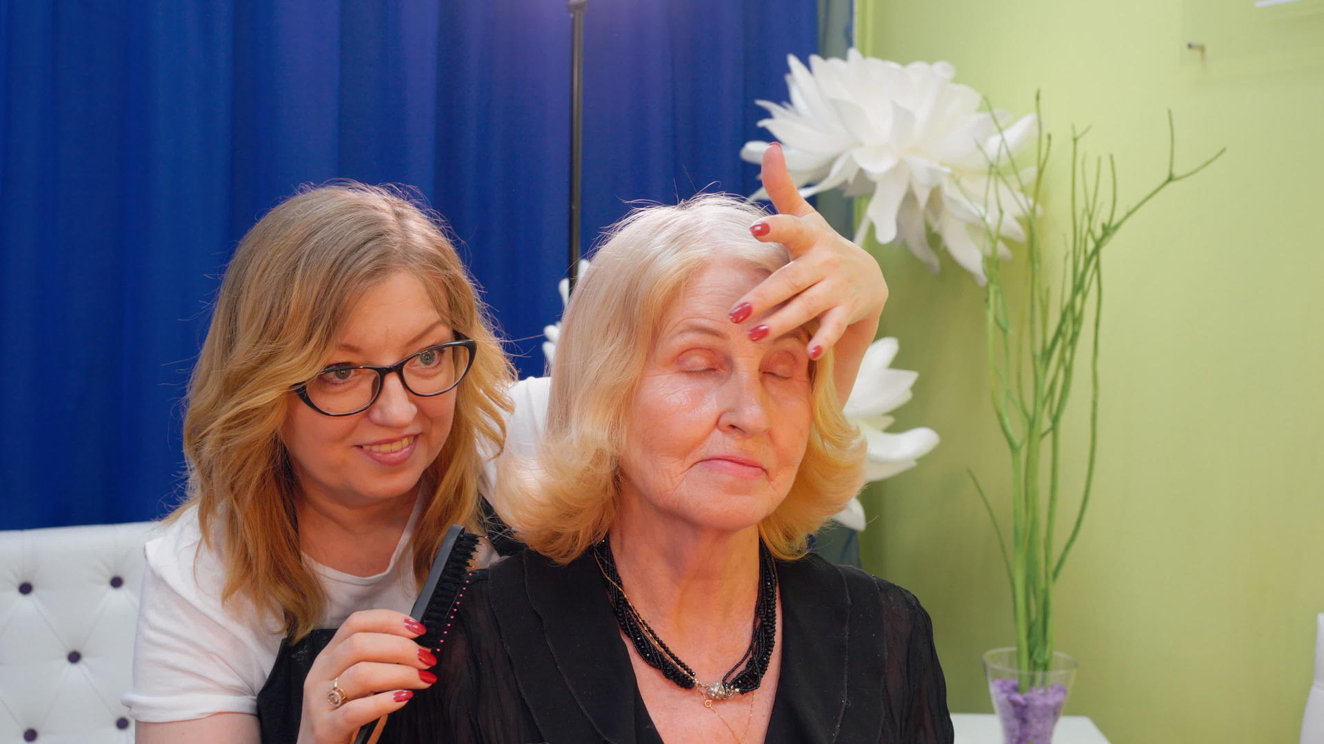 发型师在美容院为金发碧眼的成熟女性做发型师视频的预览图