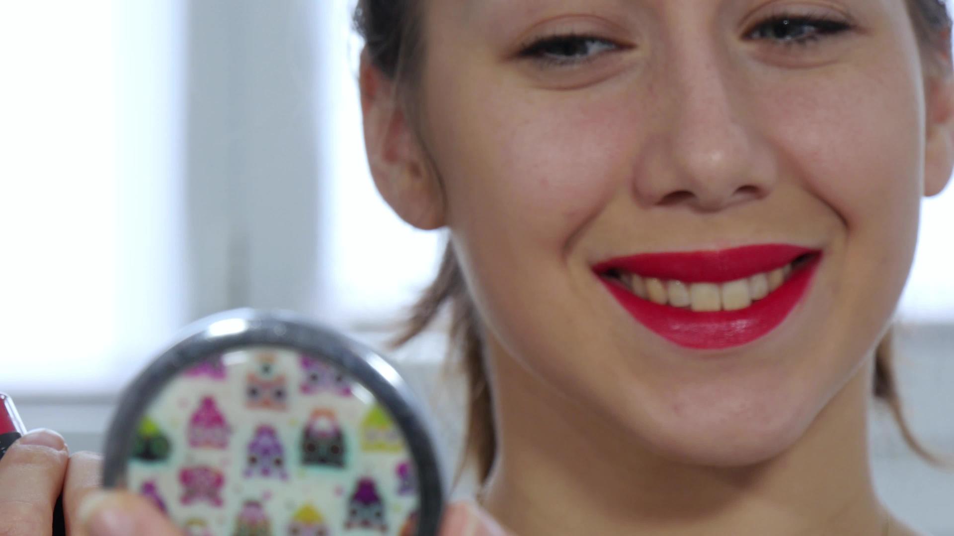 年轻和微笑的女人涂口红视频的预览图
