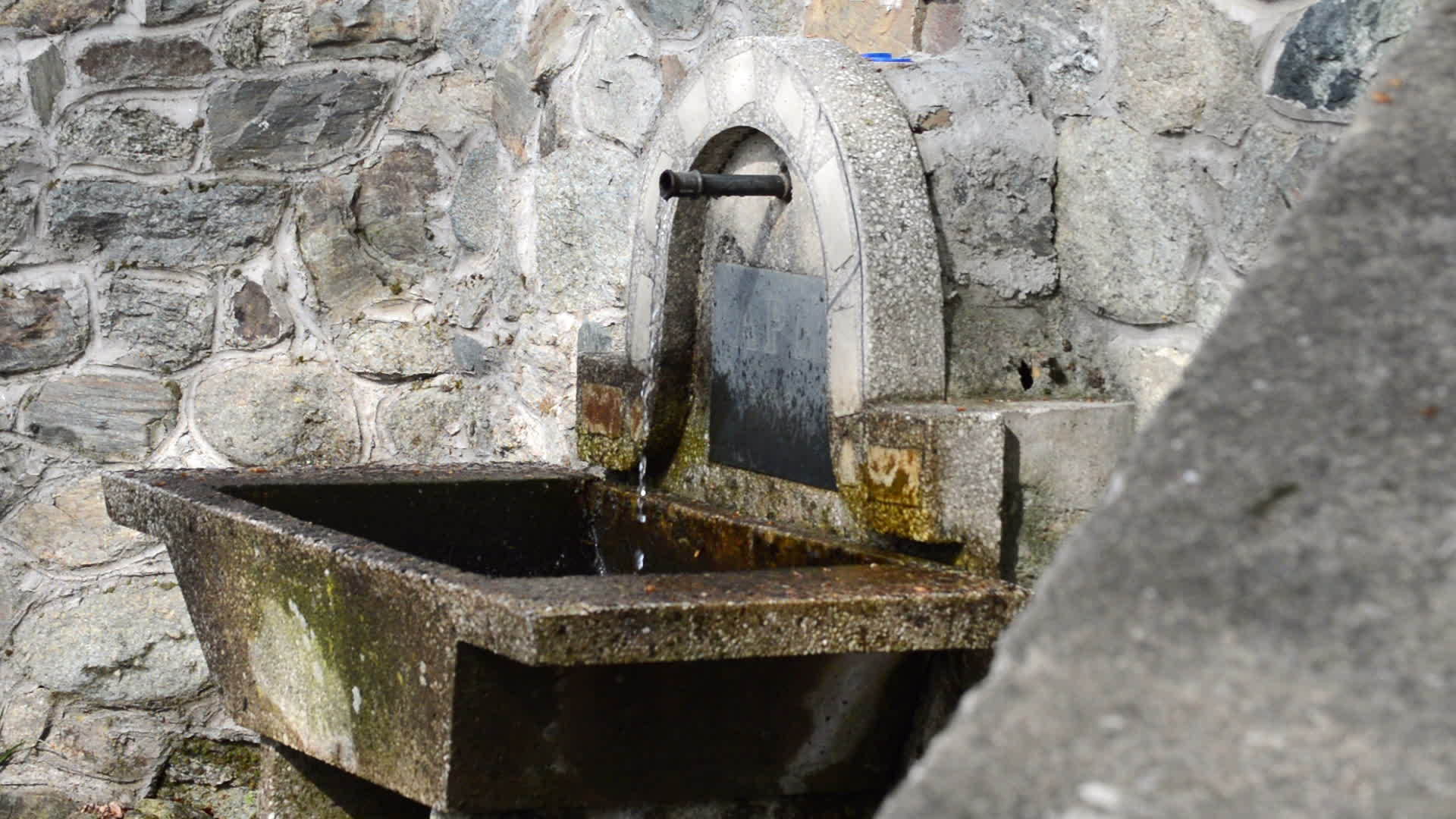 从金属管喷泉池从侧面流出的清冷水视频的预览图