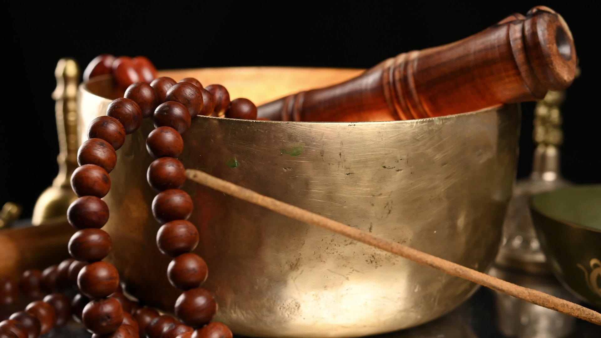 铜碗棕色木桌上有木梆子冥想和替代药物视频的预览图