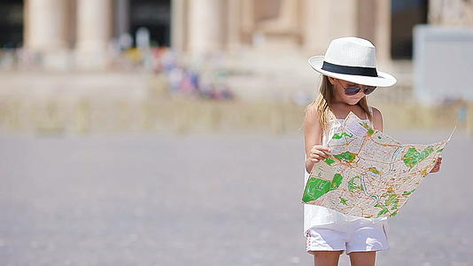 这个可爱的小女孩在圣彼得斯巴西里卡广场的意大利有一张旅行地图视频的预览图
