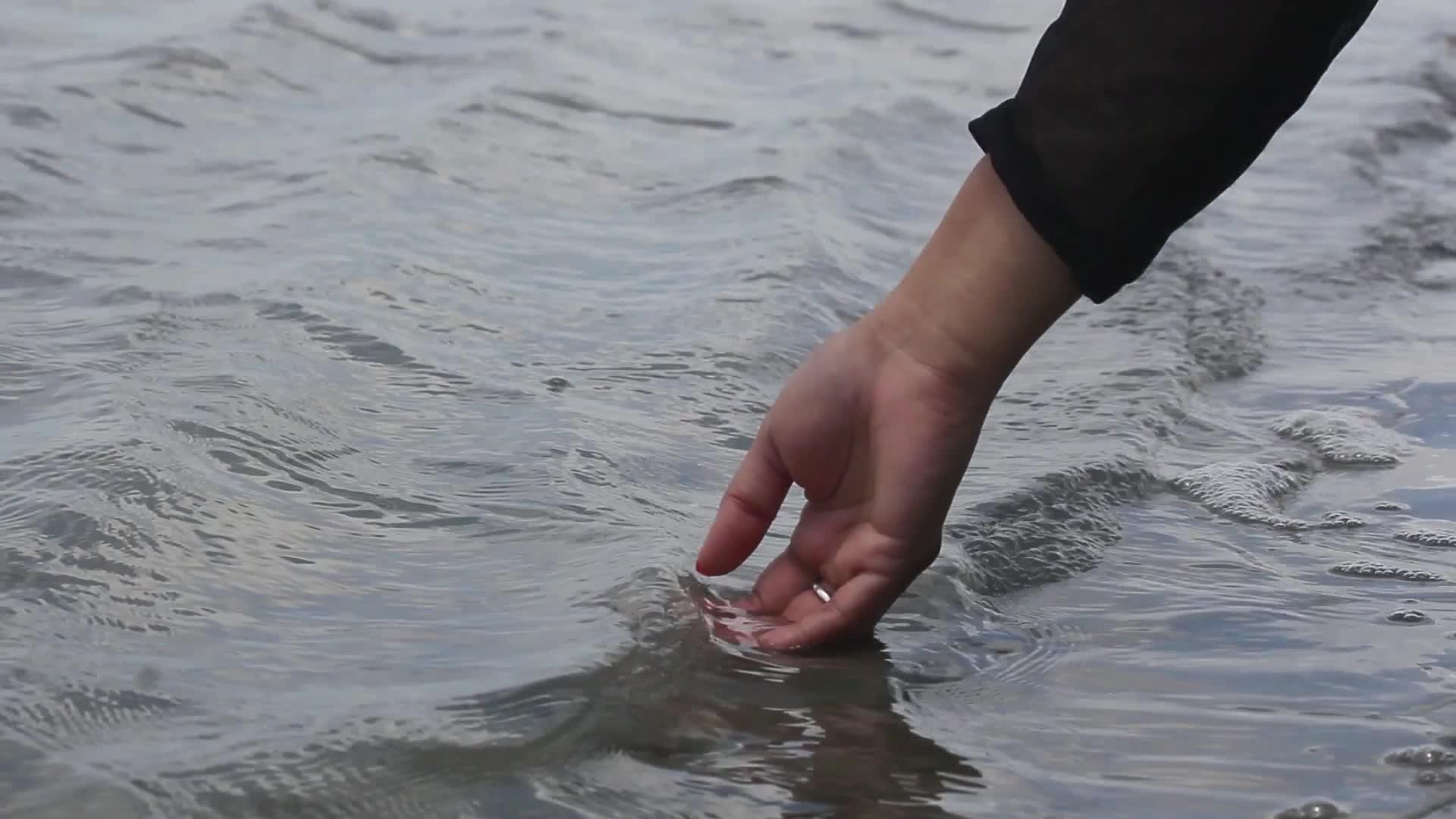 一名旅游妇女触摸海水视频的预览图
