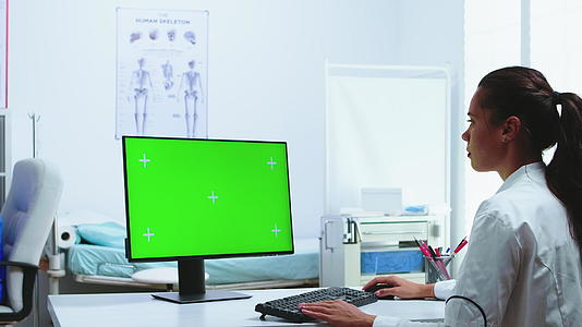 医生使用带有绿色屏幕显示的电脑视频的预览图