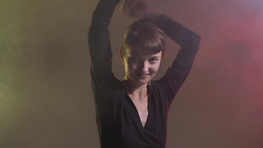 可爱的女孩跳舞烟雾丰富多彩的背景视频的预览图