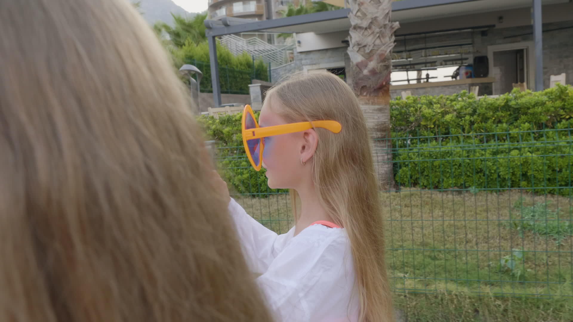 可爱的女孩戴着有趣的太阳镜在街上行走视频的预览图
