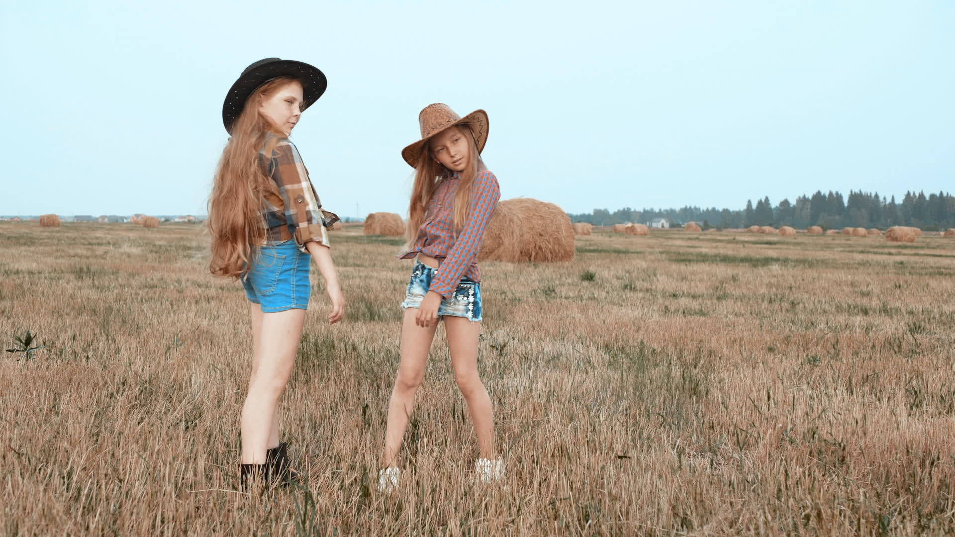 两个戴着帽子的可爱女孩在野外打扮在一起视频的预览图