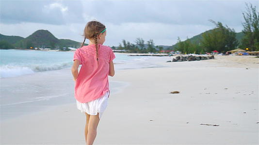 海滩上可爱的小女孩在卡比巴岛玩得开心又慢视频的预览图