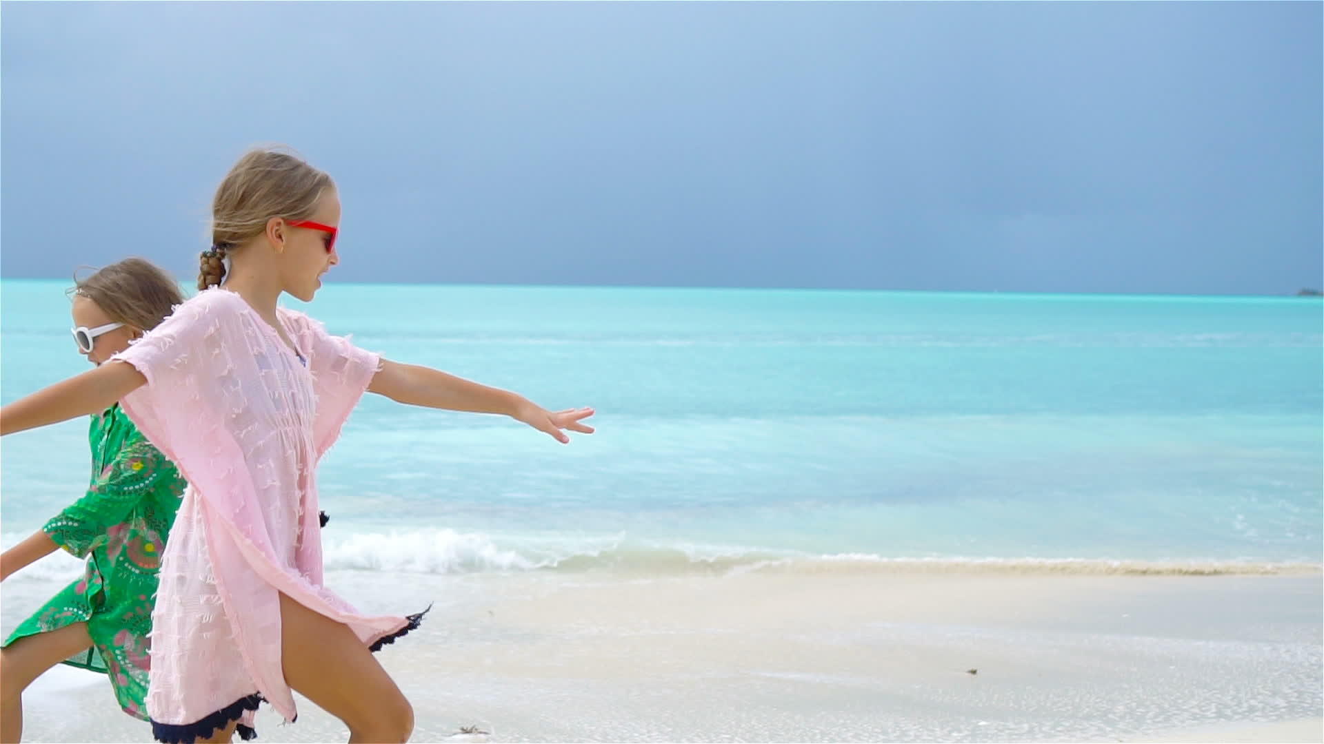 可爱的小女孩在海滩上慢慢地移动视频的预览图