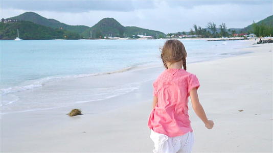 海滩上可爱的小女孩在卡比巴岛玩得开心又慢视频的预览图