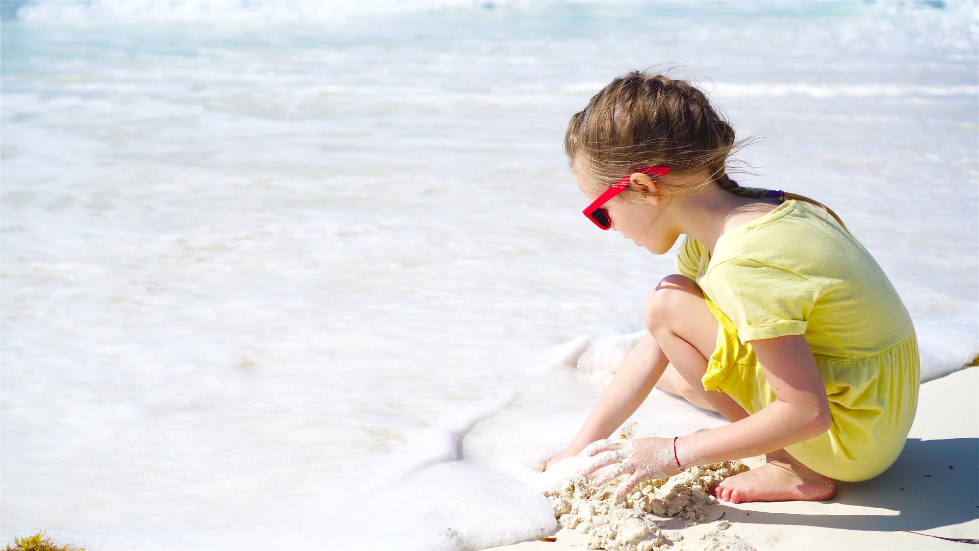 可爱的小女孩热带沙滩造沙城堡视频的预览图