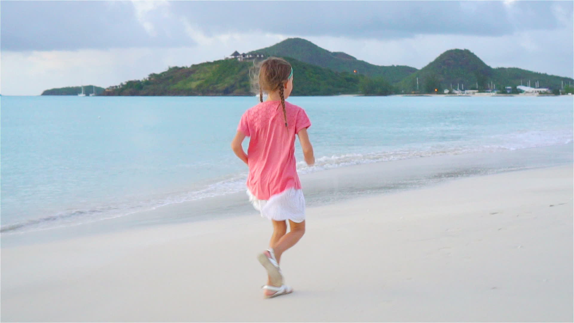日落时小女孩走在海滩上视频的预览图