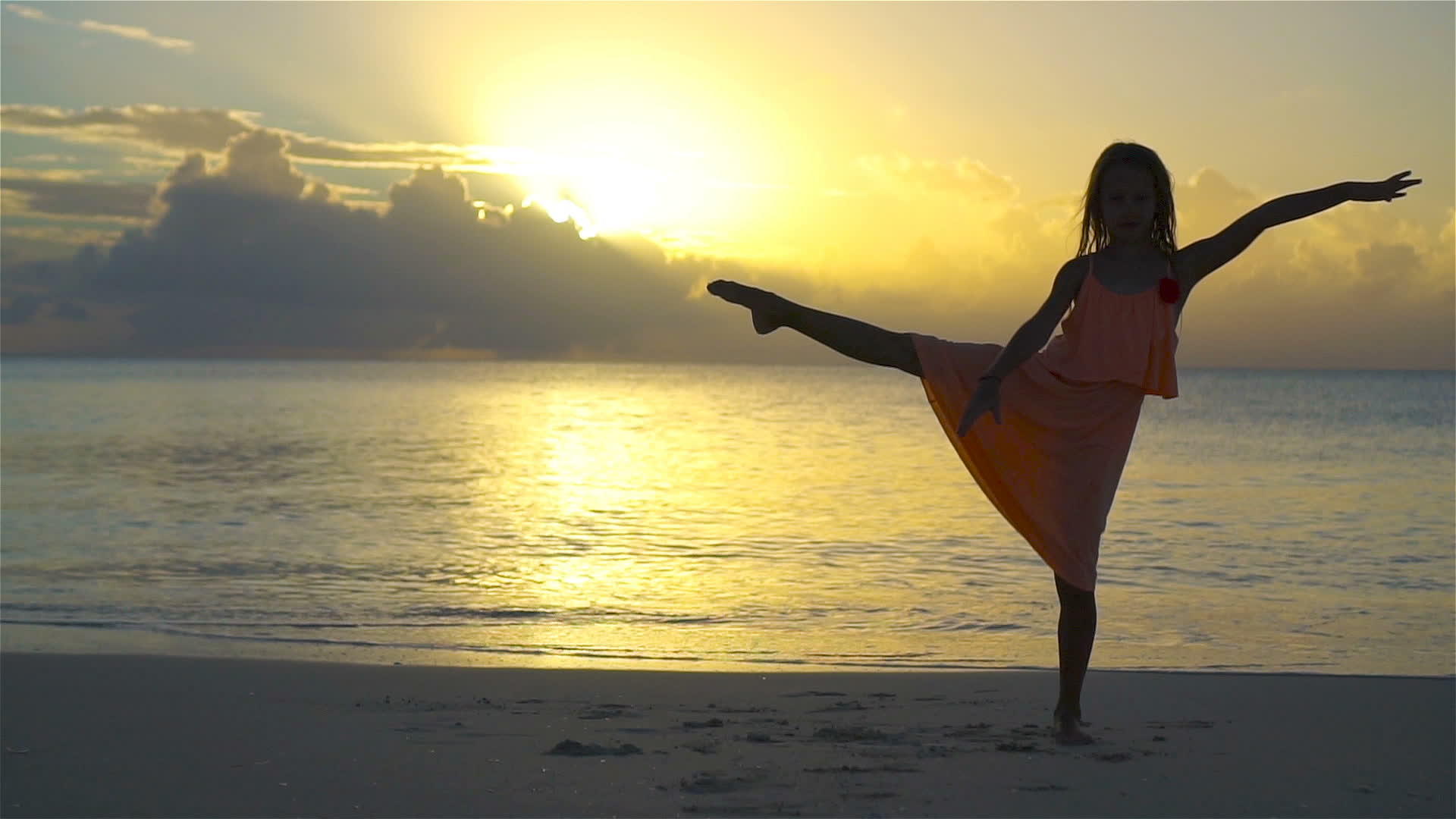 可爱的小女孩在白色沙滩上日落时的慢动作视频的预览图