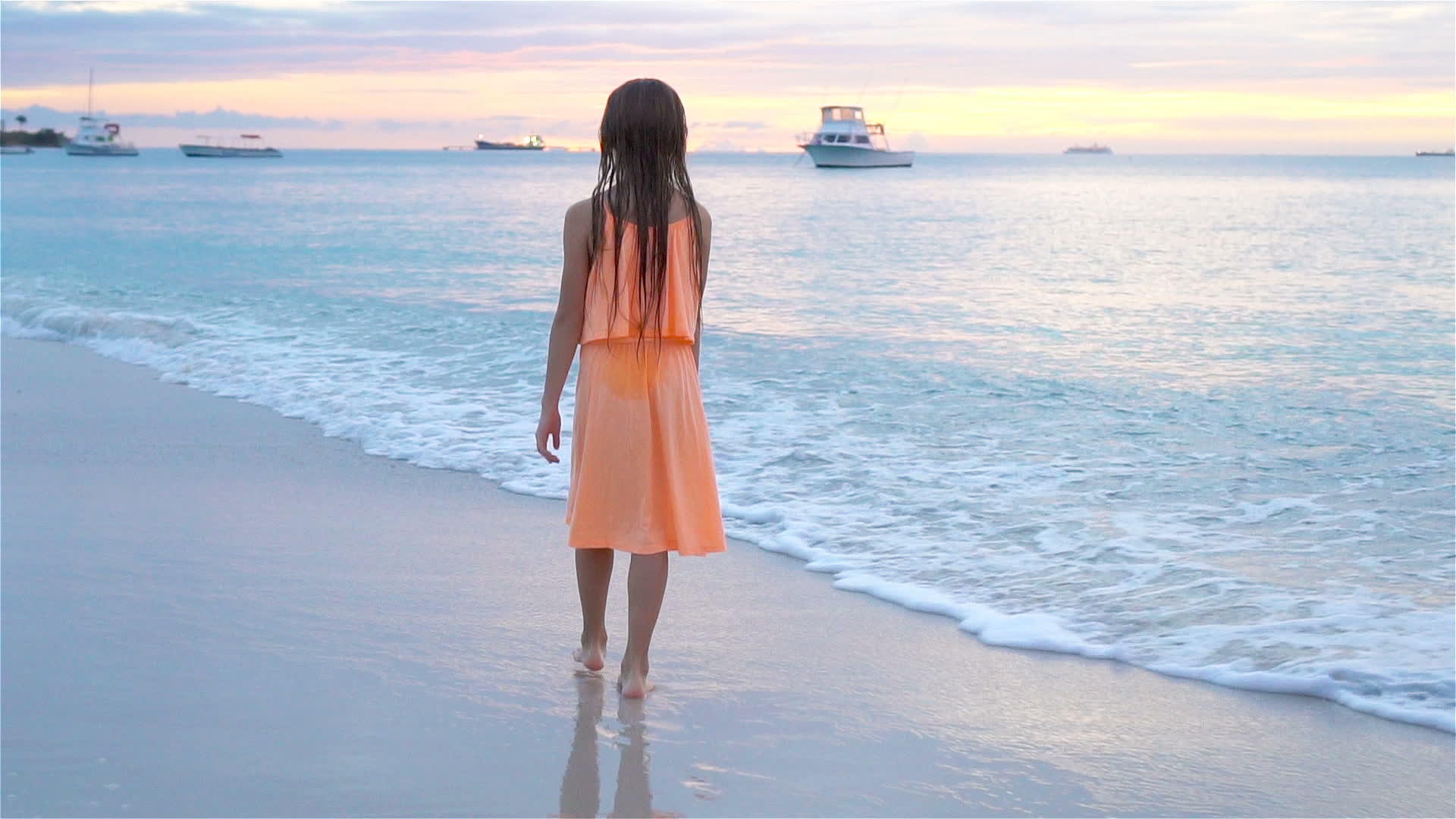 可爱快乐的小女孩日落时在白色沙滩上行走视频的预览图