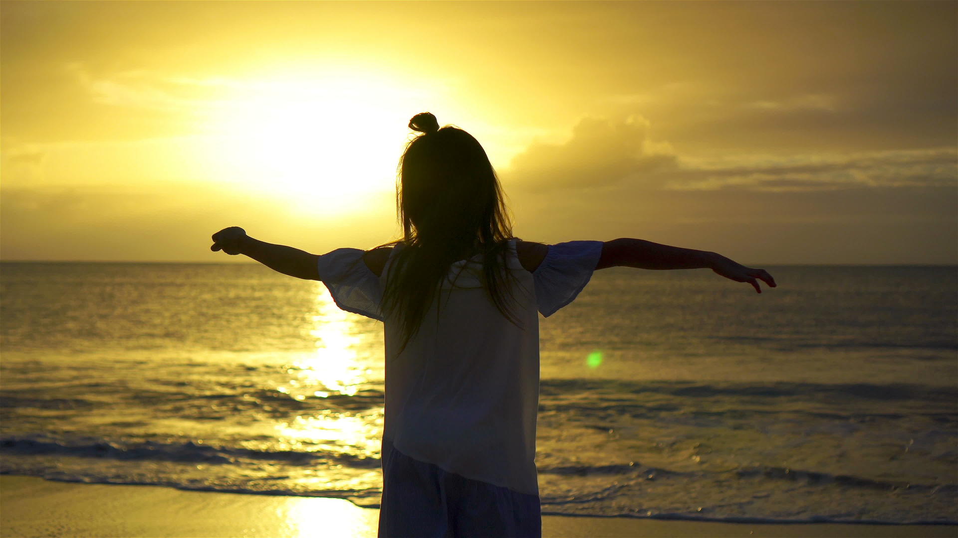 日落时快乐的小女孩在白色的海滩上美丽的日落海岸视频的预览图