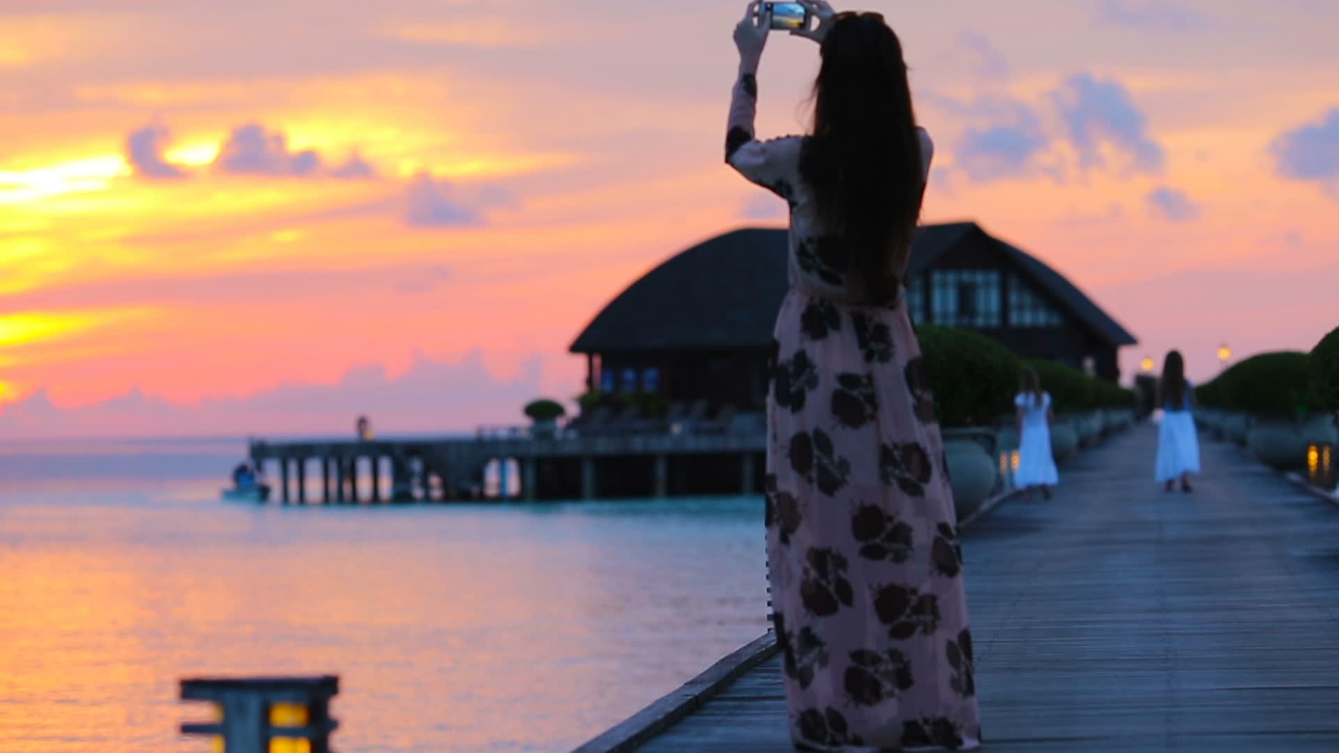 年轻女青年在热带度假期间拍摄美丽日落的照片视频的预览图