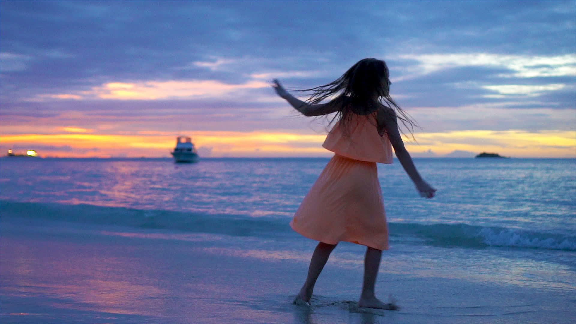 小女孩日落时在海滩上跳舞视频的预览图