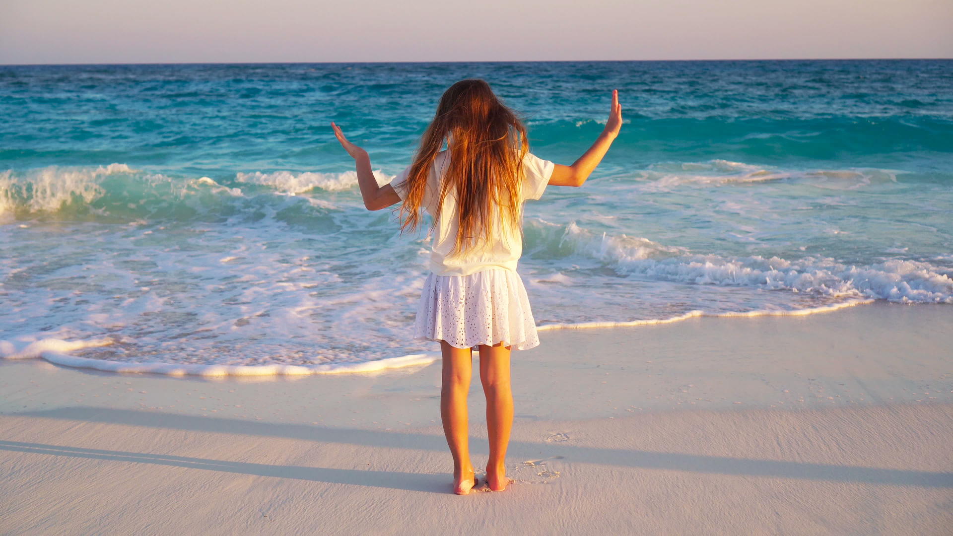 可爱快乐的小女孩在热带海滩日落视频的预览图