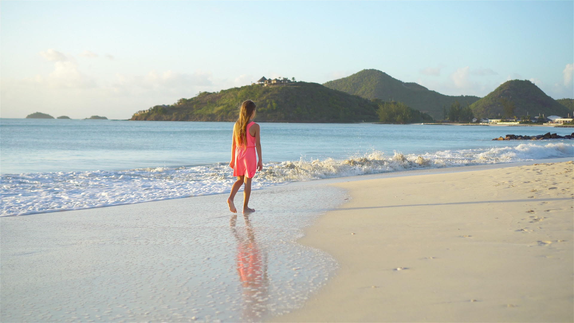 可爱快乐的小女孩在白色沙滩上慢慢地走来走去视频的预览图