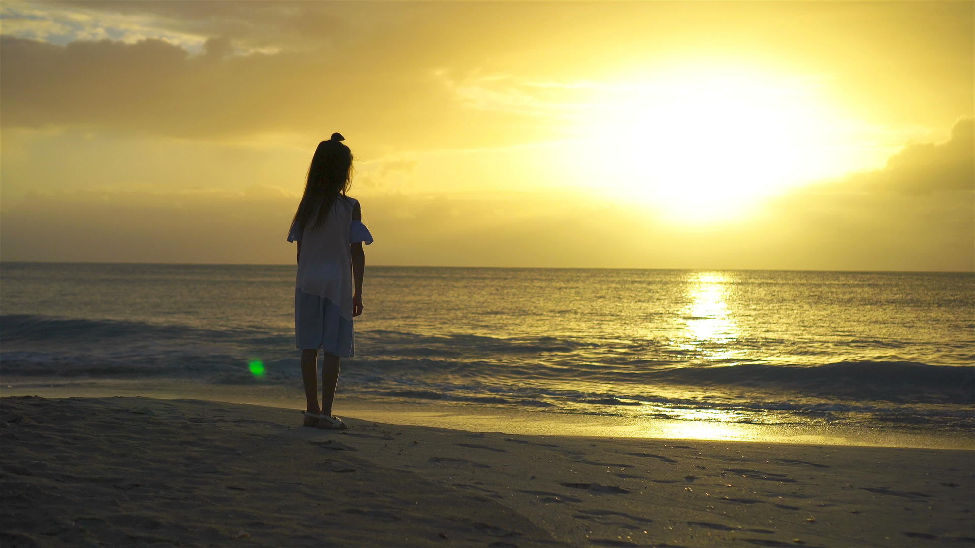 快乐的小女孩日落时在白色沙滩上散步视频的预览图
