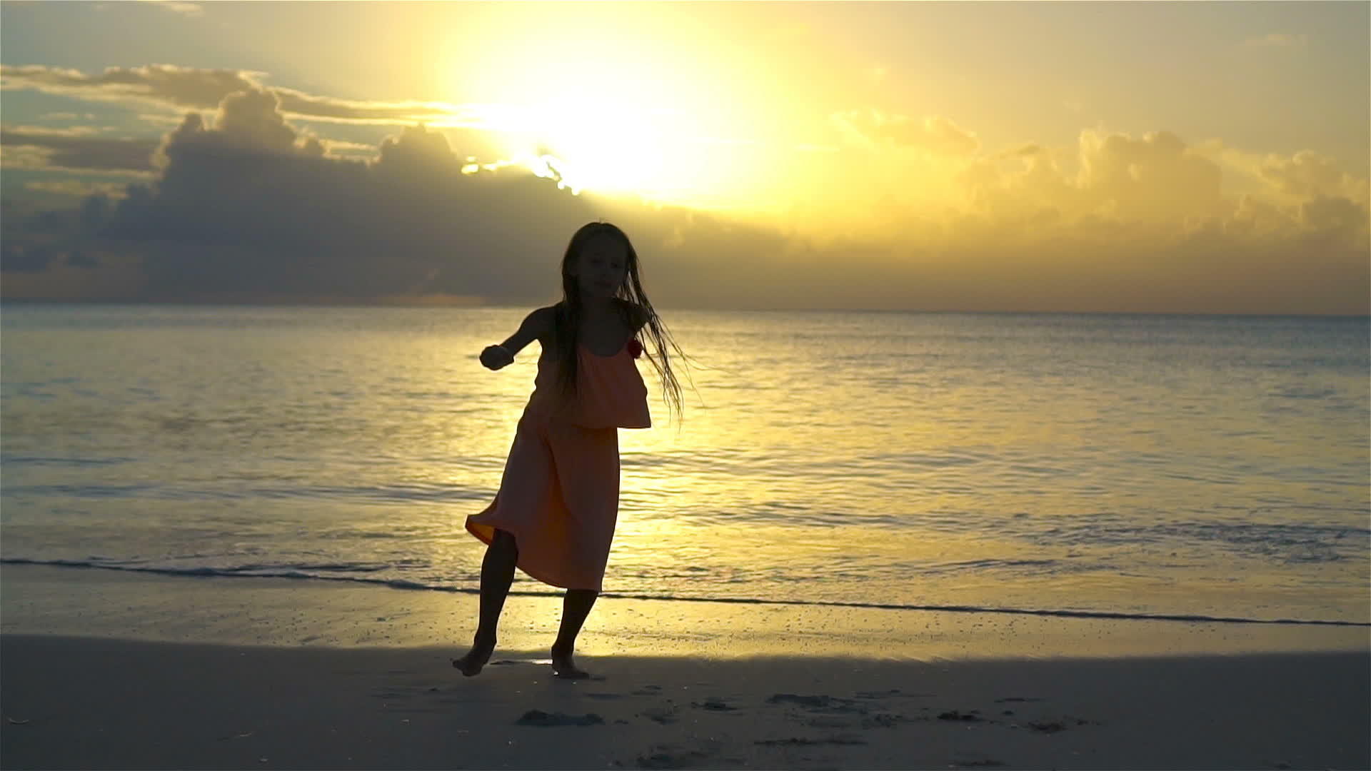 这个可爱快乐的小女孩在日落时在白色的海滩上玩得很开心视频的预览图