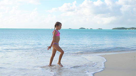 可爱快乐的小女孩在白色沙滩上玩得很开心视频的预览图