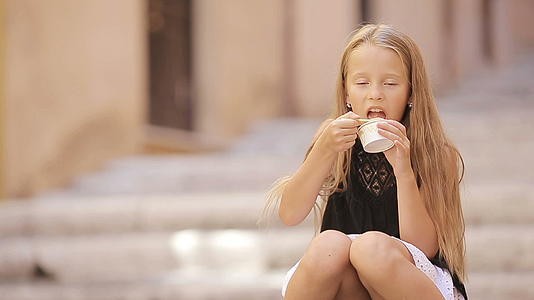 可爱的少年在欧洲城市吃冰淇淋视频的预览图