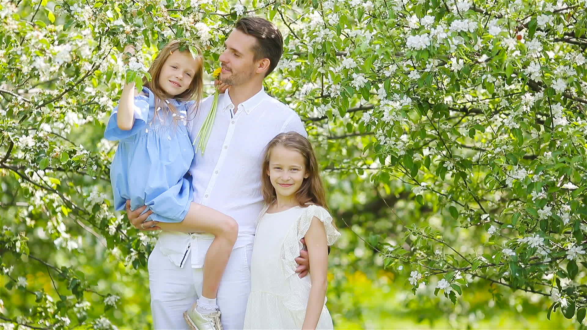 在美丽的春天在开花的花园里幸福的家庭视频的预览图