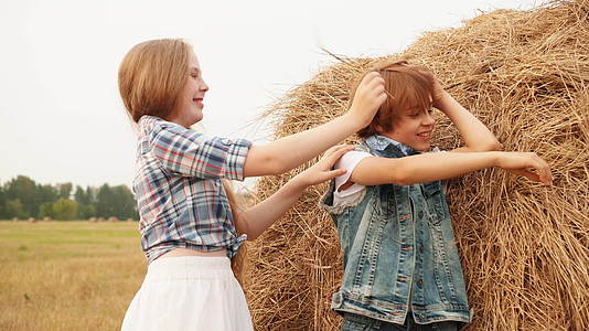 可爱快乐的男孩女孩在田里玩干草视频的预览图
