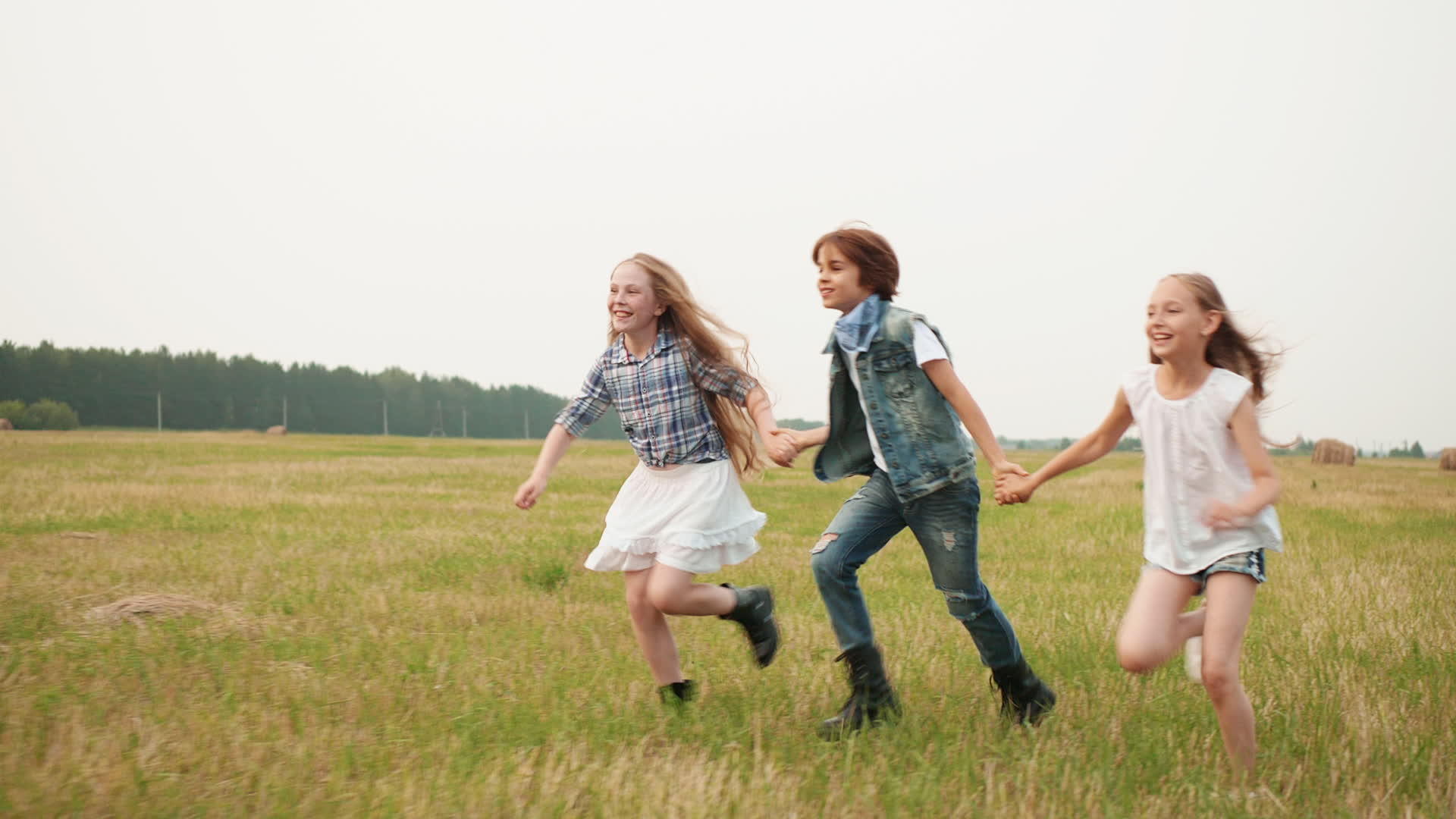 可爱快乐的青少年手牵手在田间奔跑视频的预览图