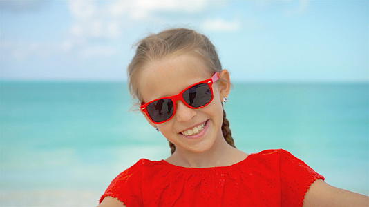 暑假期间快乐的小女孩在奇怪的岛屿热带海滩自拍视频的预览图