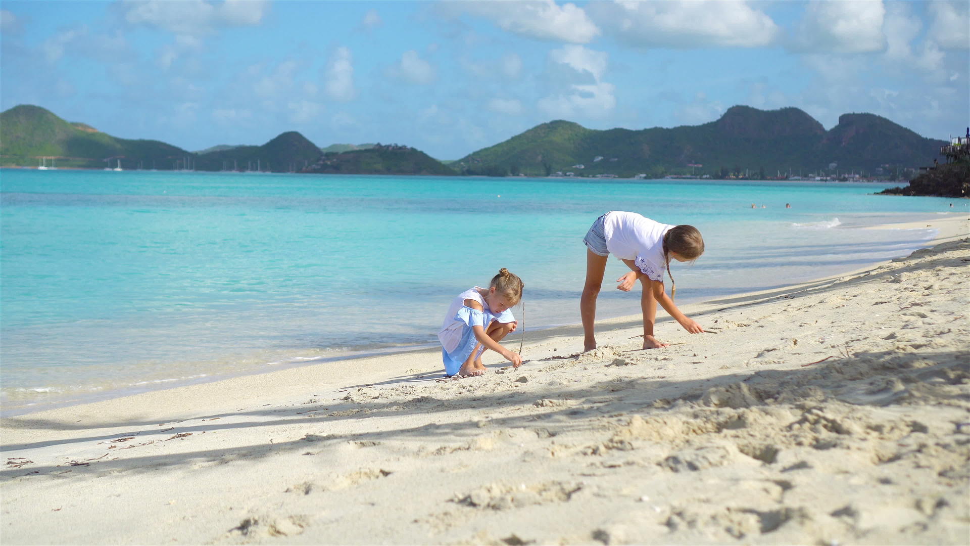 两个孩子在热带海滩上建造沙城堡和玩耍视频的预览图