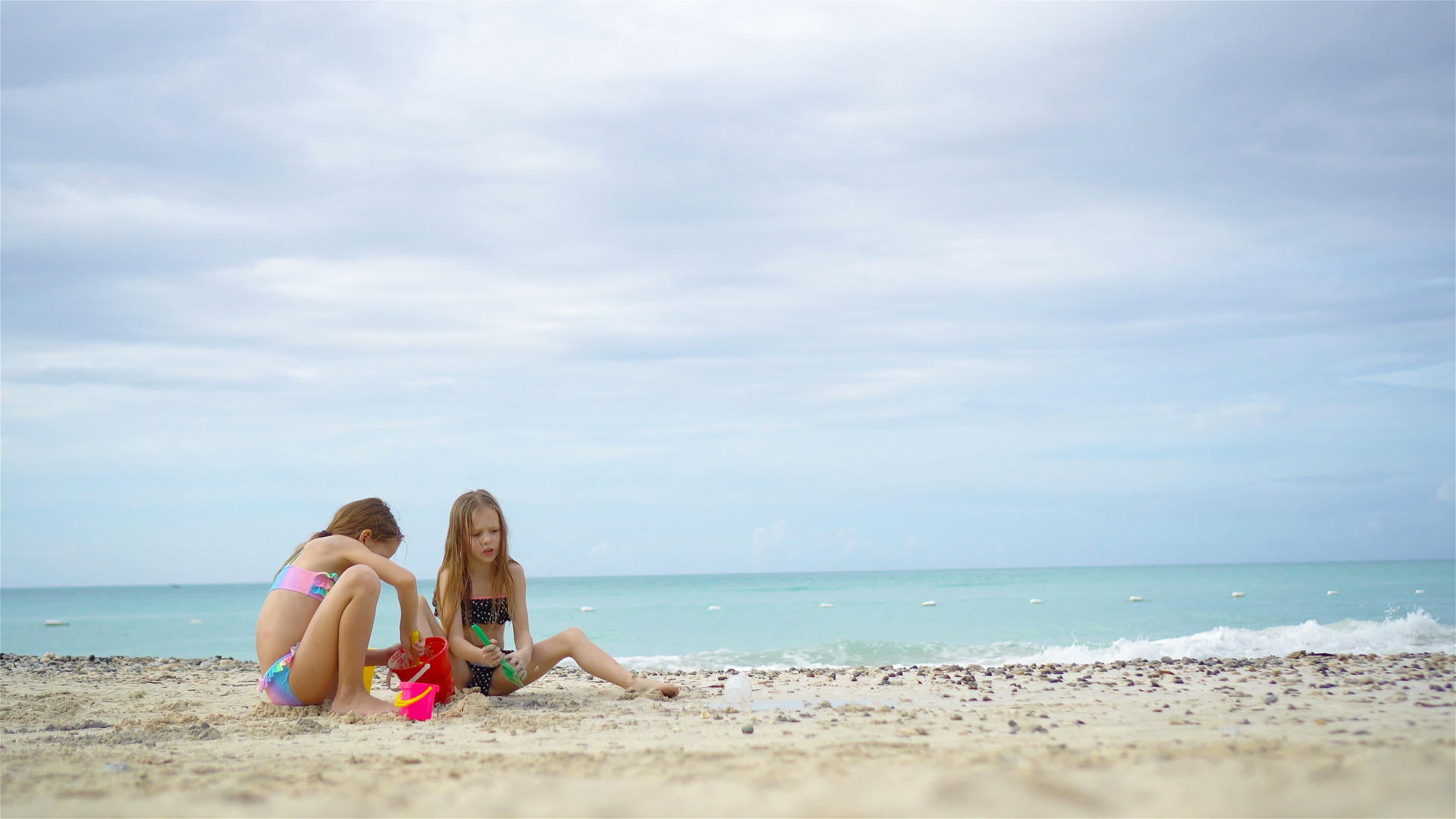 两个孩子在热带海滩上建造沙堡玩得很开心视频的预览图