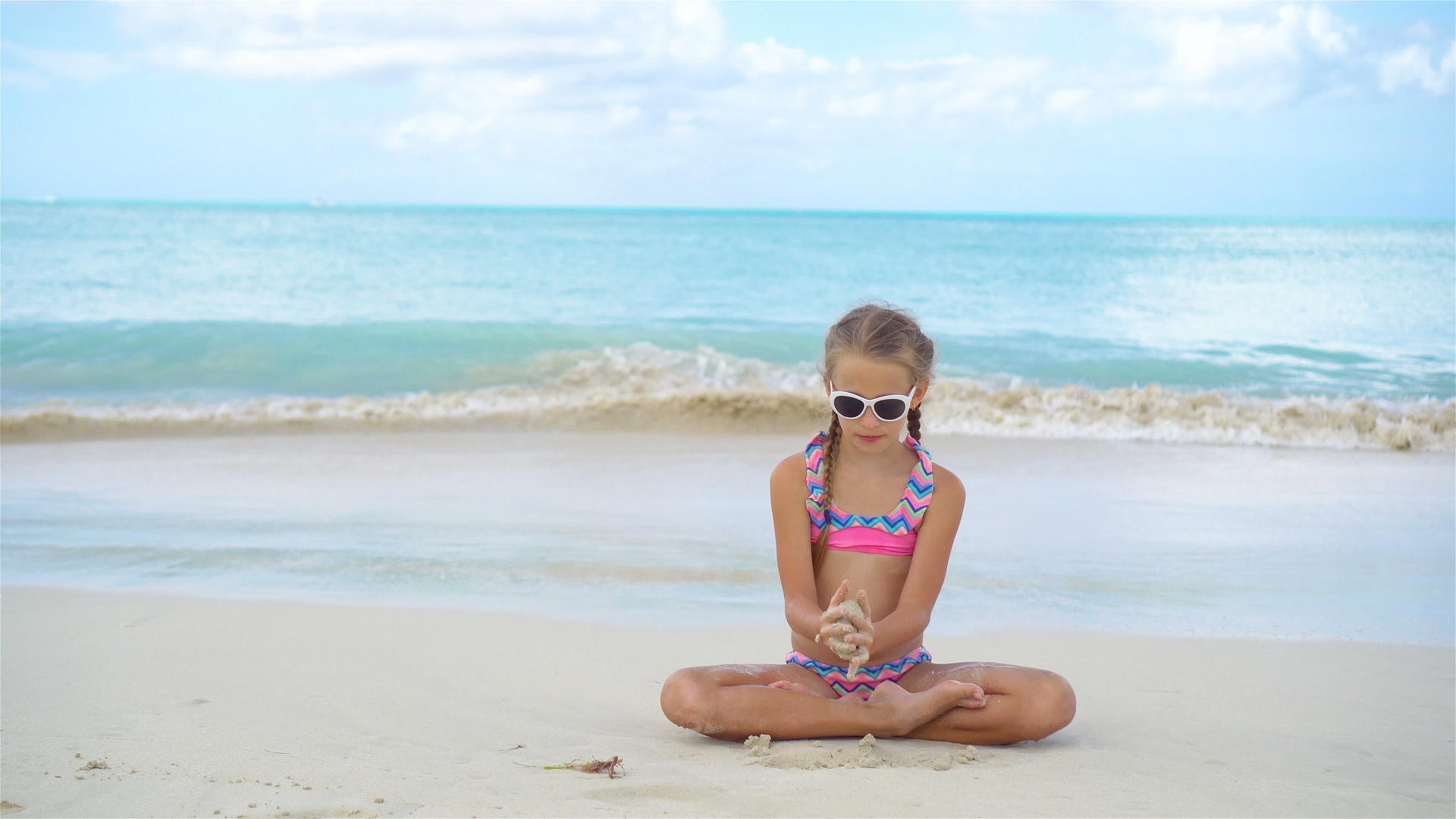 可爱的小女孩暑假在沙滩上玩视频的预览图