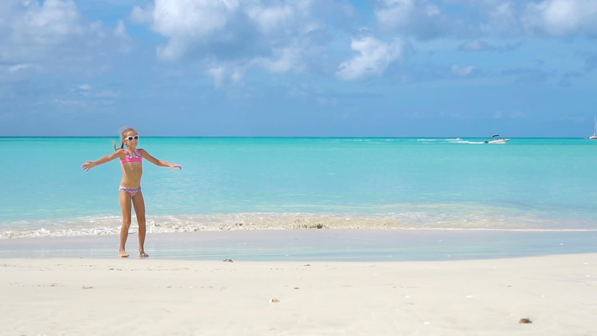 暑假期间活跃的小女孩在海滩上玩耍视频的预览图