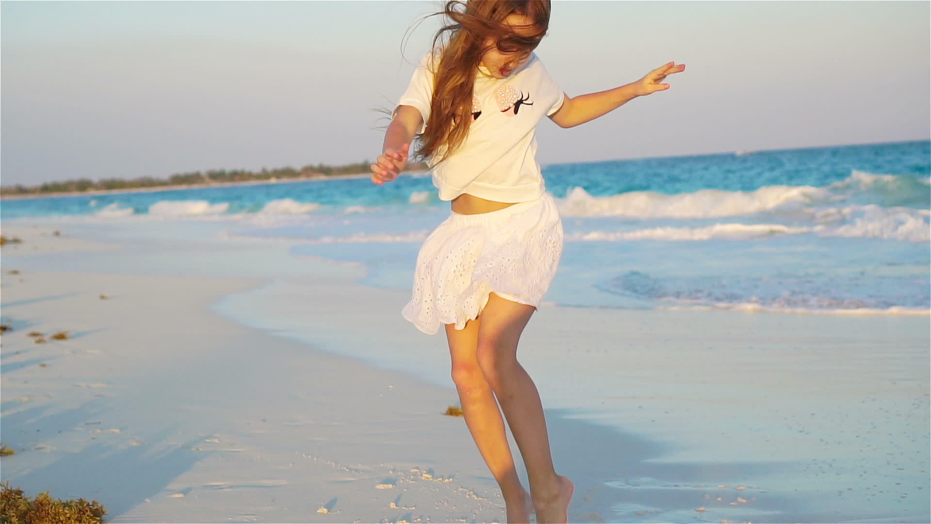 活跃在海滩上的小女孩在海滩上快乐地跳舞视频的预览图