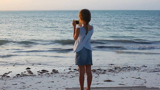 热带度假期间海滩上可爱的小女孩视频的预览图