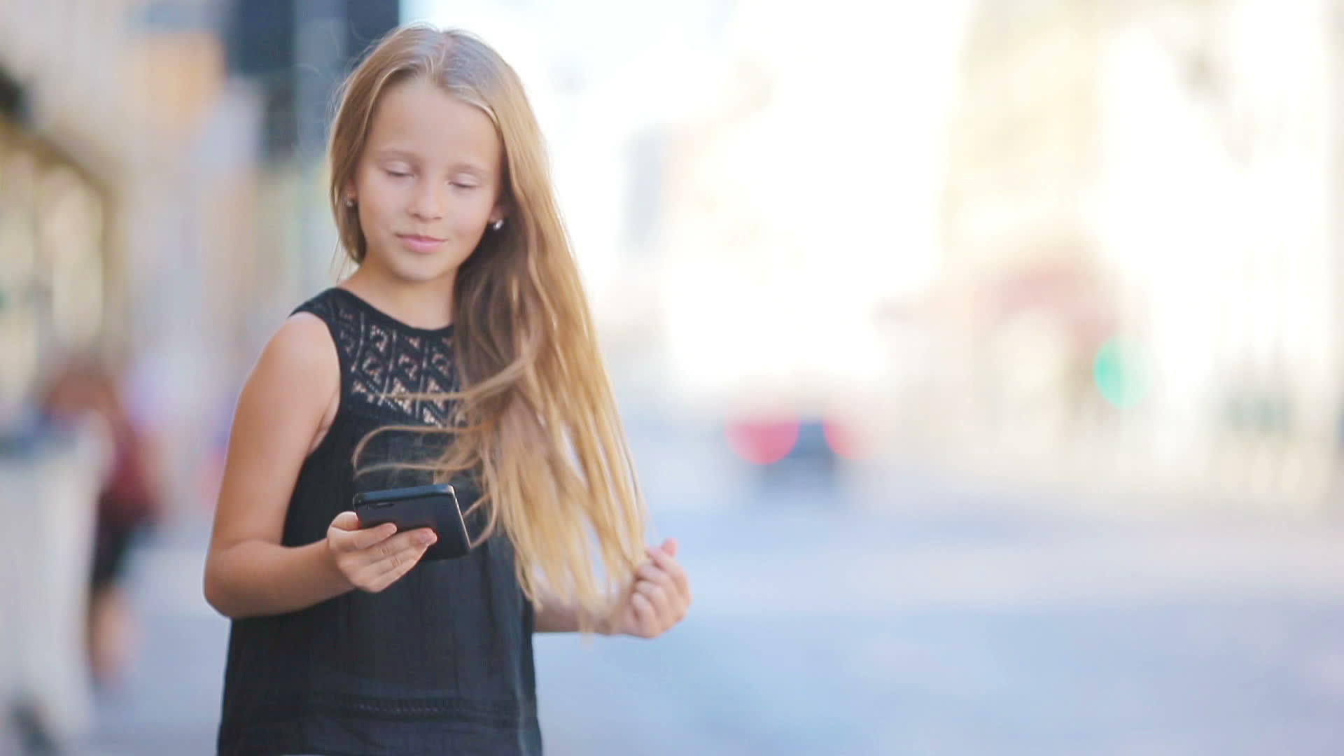 可爱的小女孩在欧洲城市有智能手机视频的预览图