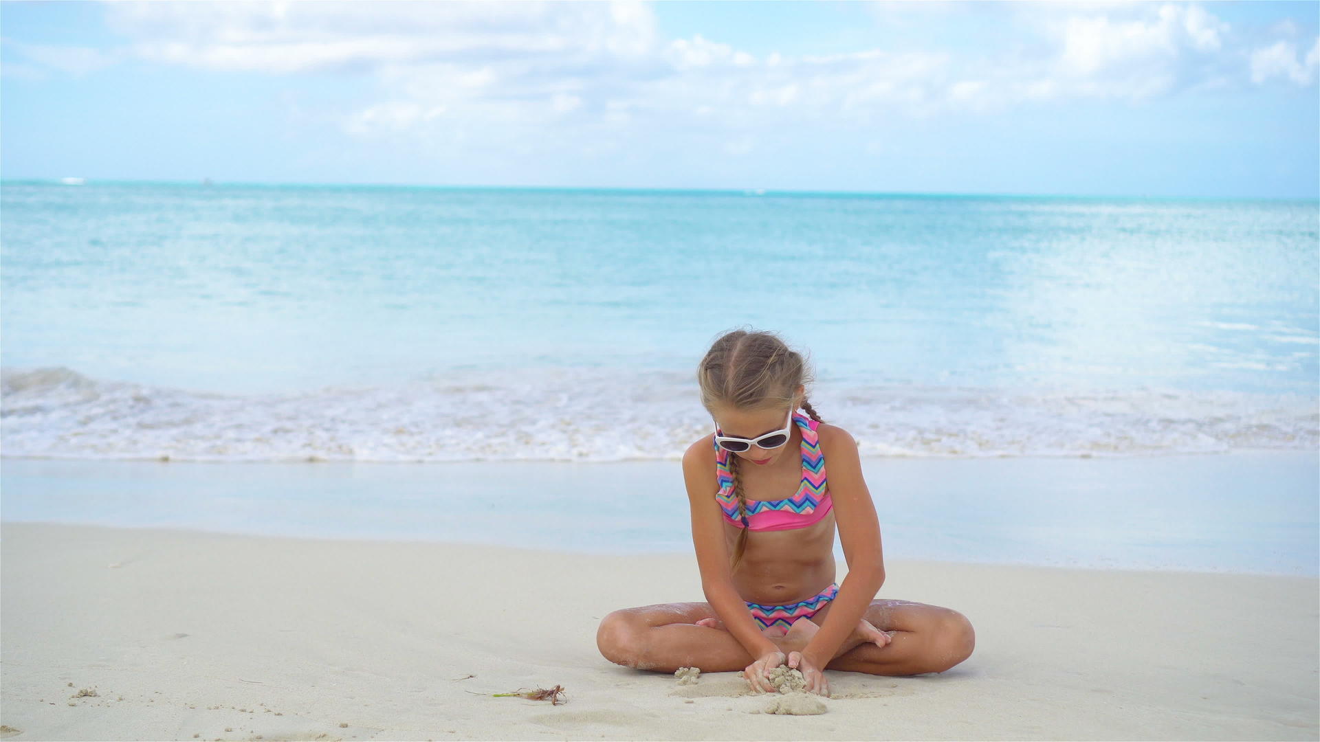 可爱活跃的小女孩在雪白的沙滩上视频的预览图