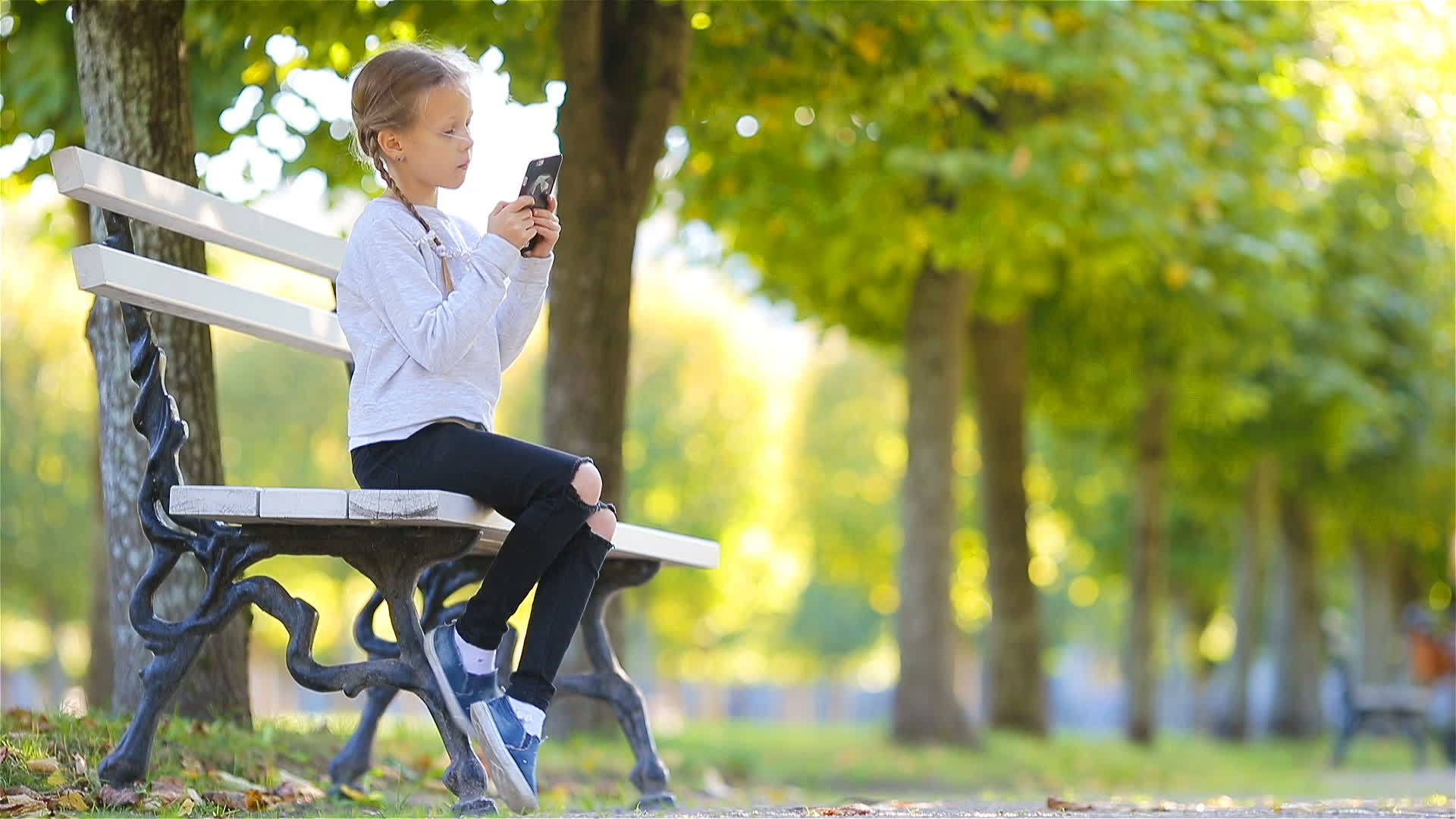 可爱的小女孩在户外美丽的秋天可爱的孩子在秋天的长凳上视频的预览图