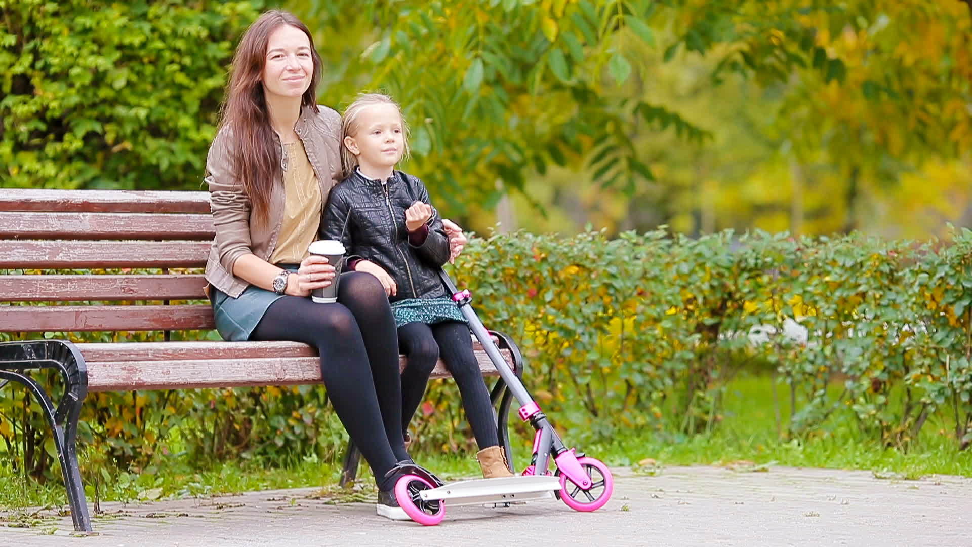 一个有妈妈的可爱小女孩享受秋天和秋天在秋天公园户外视频的预览图