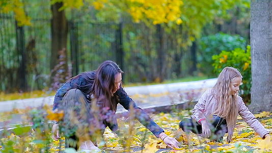 秋天公园里可爱的小女孩和快乐的母亲视频的预览图