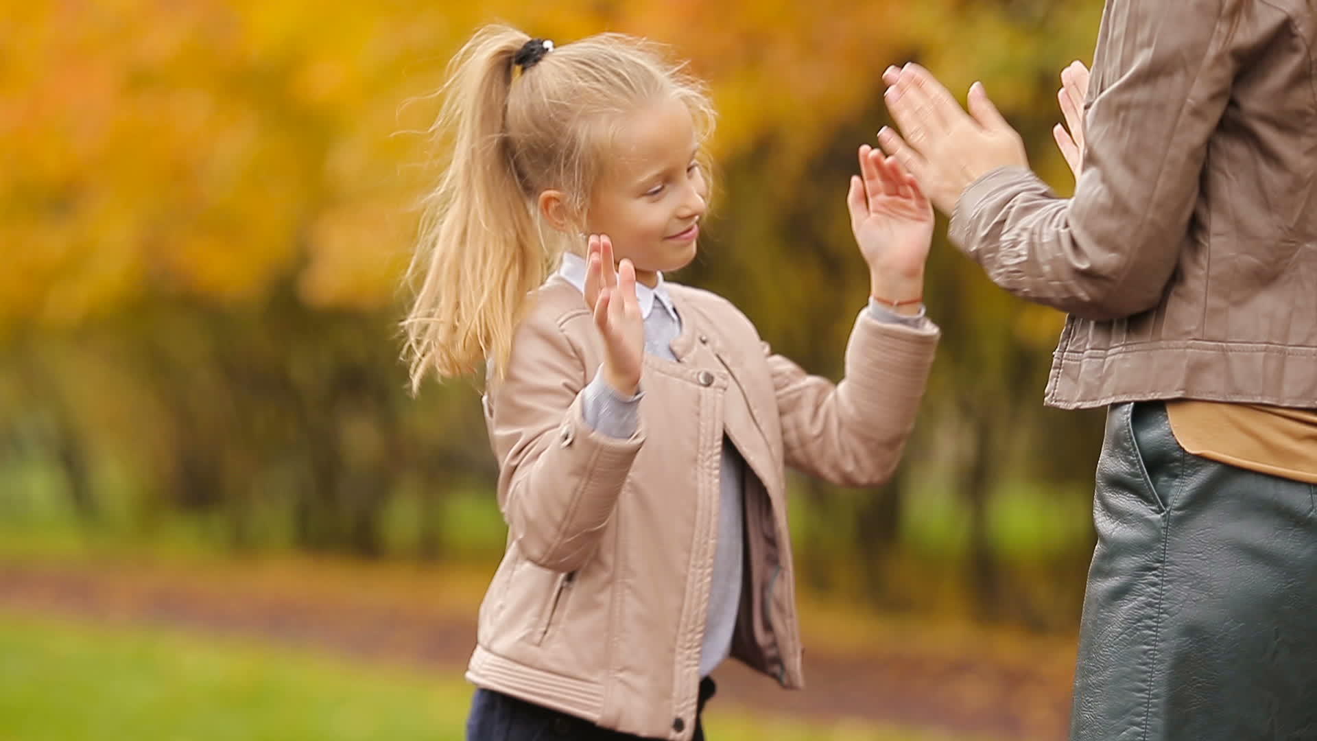 快乐的母亲和可爱的女孩在秋天的公园里露天视频的预览图