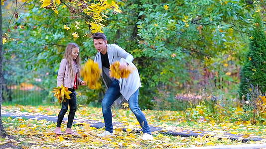 可爱的小女孩和快乐的父母在户外秋季公园享受秋天视频的预览图
