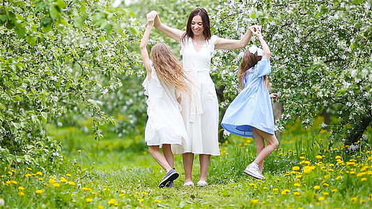 可爱的小女孩年轻的母亲在花园里开花快乐地分享美丽的春天视频的预览图